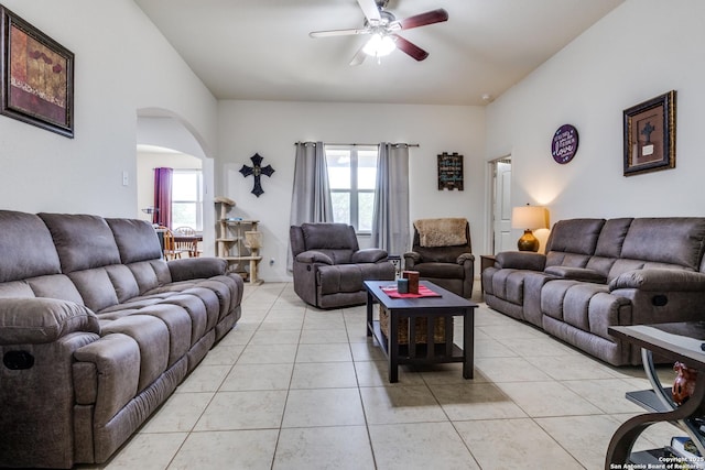 living area featuring arched walkways, plenty of natural light, and light tile patterned floors