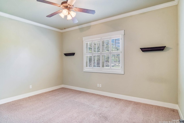 carpeted spare room with baseboards, a ceiling fan, and crown molding
