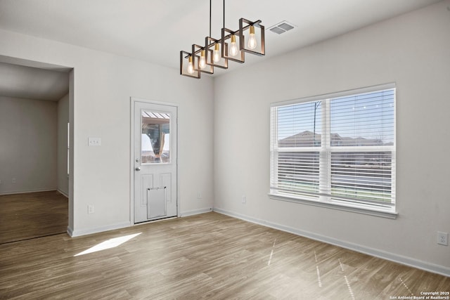 interior space featuring visible vents, baseboards, and wood finished floors