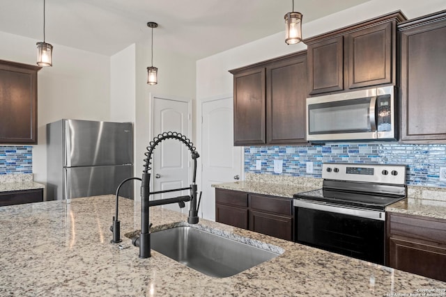 kitchen with decorative light fixtures, decorative backsplash, appliances with stainless steel finishes, a sink, and dark brown cabinetry