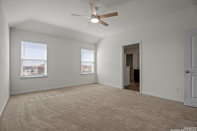 unfurnished bedroom with lofted ceiling, carpet, baseboards, and ensuite bathroom