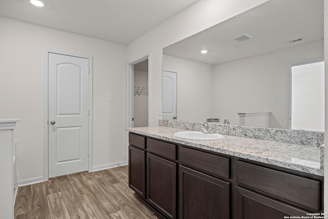 bathroom featuring recessed lighting, visible vents, vanity, wood finished floors, and baseboards