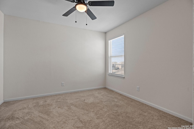 carpeted spare room with ceiling fan and baseboards