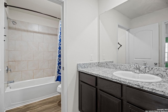 bathroom with toilet, shower / bath combination with curtain, wood finished floors, and vanity