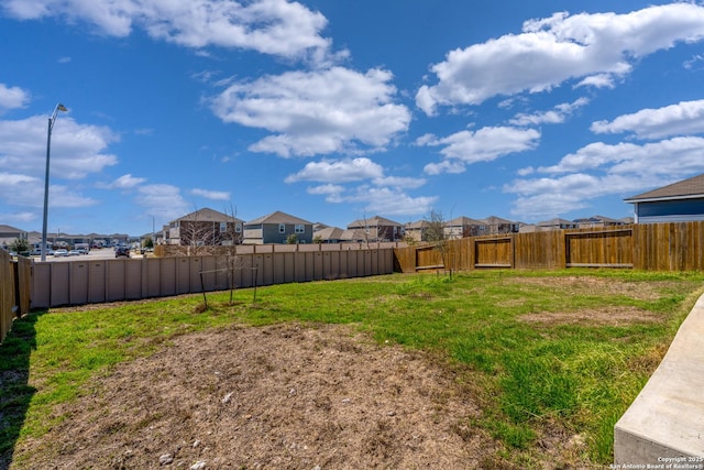 view of yard with a fenced backyard and a residential view