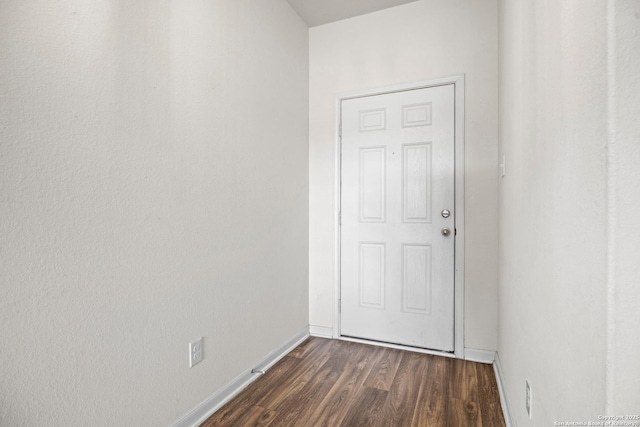 entryway featuring dark wood-type flooring and baseboards