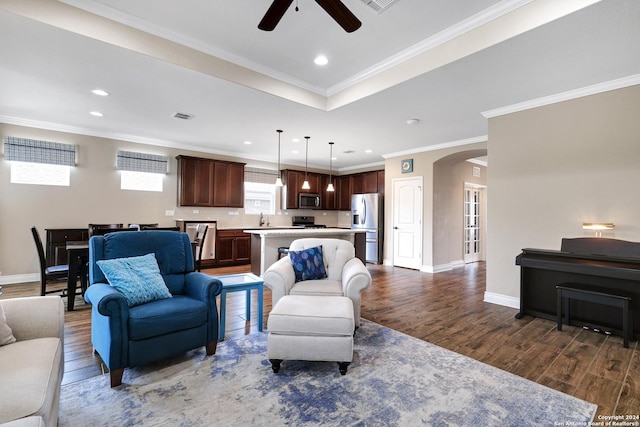 living area with baseboards, arched walkways, visible vents, dark wood-type flooring, and crown molding