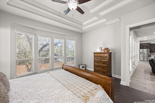 bedroom with stainless steel fridge with ice dispenser, a raised ceiling, visible vents, wood finished floors, and baseboards