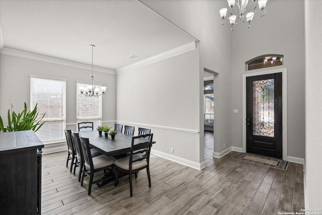 dining area with wood finished floors, a wealth of natural light, and an inviting chandelier