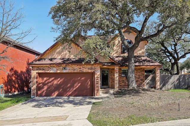 view of front of property featuring a garage, driveway, brick siding, and fence