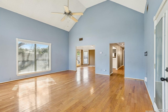 interior space featuring ceiling fan, high vaulted ceiling, visible vents, baseboards, and light wood-style floors