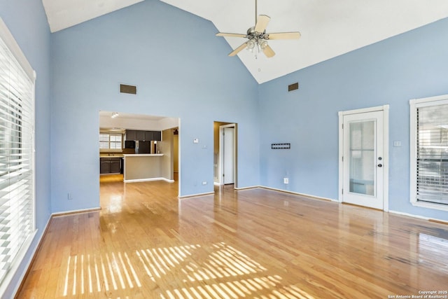 unfurnished living room featuring light wood-style floors, visible vents, high vaulted ceiling, and a ceiling fan