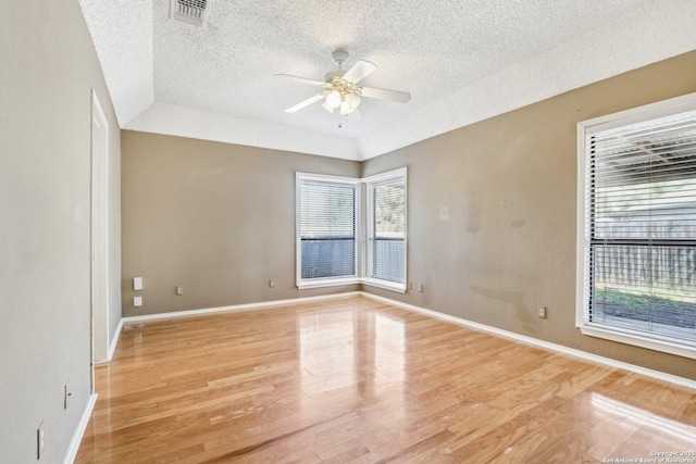 unfurnished room featuring visible vents, plenty of natural light, light wood finished floors, and ceiling fan