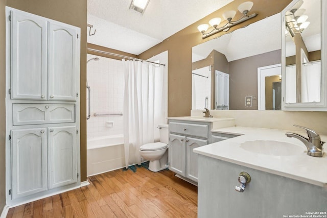 bathroom featuring toilet, wood finished floors, visible vents, vanity, and shower / bath combo