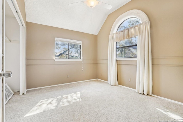 interior space with lofted ceiling, visible vents, a ceiling fan, and a healthy amount of sunlight