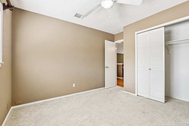 unfurnished bedroom with carpet floors, a closet, visible vents, ceiling fan, and baseboards