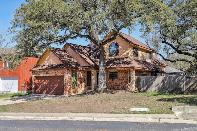 view of front of home featuring a garage, concrete driveway, brick siding, and fence