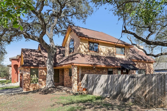 view of front of house with fence and brick siding