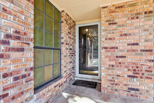 doorway to property featuring brick siding