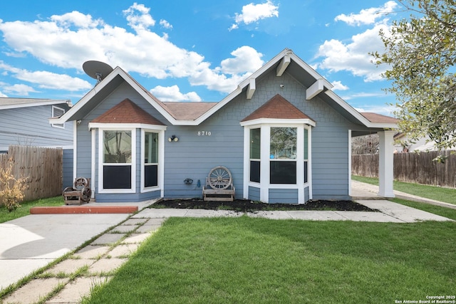 view of front facade with a patio, a front yard, and fence