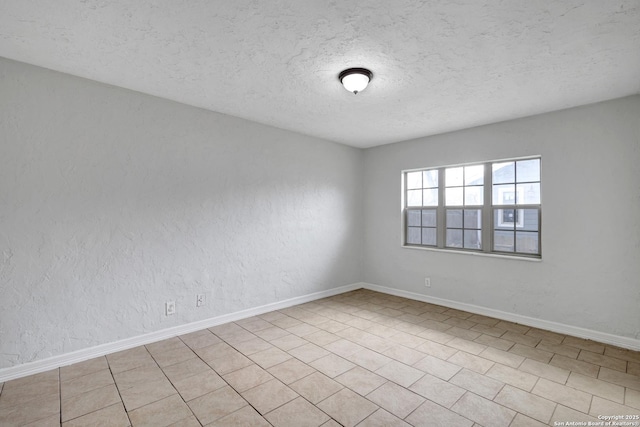 empty room featuring baseboards, a textured ceiling, and a textured wall