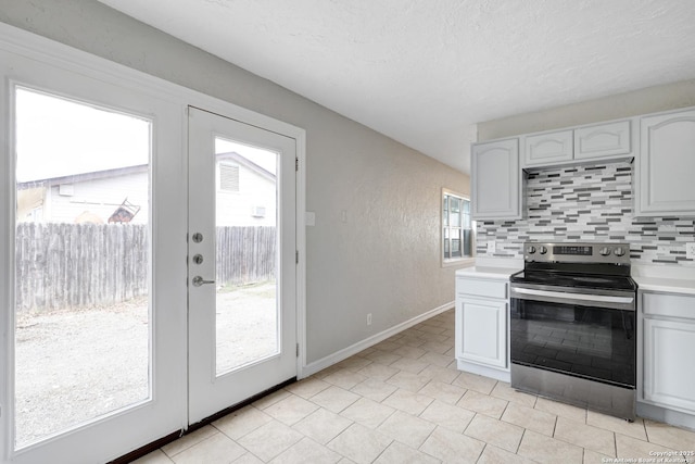 kitchen with stainless steel electric stove, light countertops, backsplash, and french doors