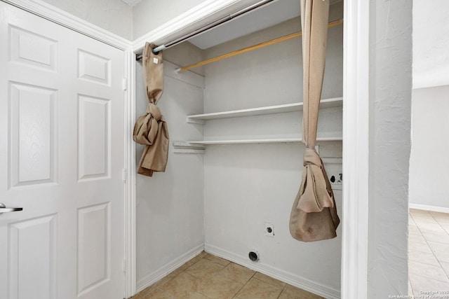 washroom with laundry area, light tile patterned floors, baseboards, and electric dryer hookup