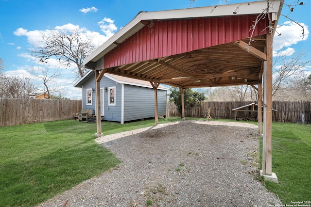 view of car parking with a carport, a fenced backyard, and driveway