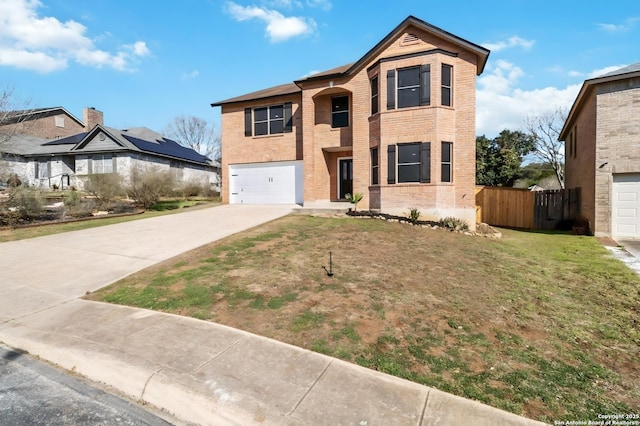 traditional-style house featuring concrete driveway, an attached garage, fence, a front lawn, and brick siding