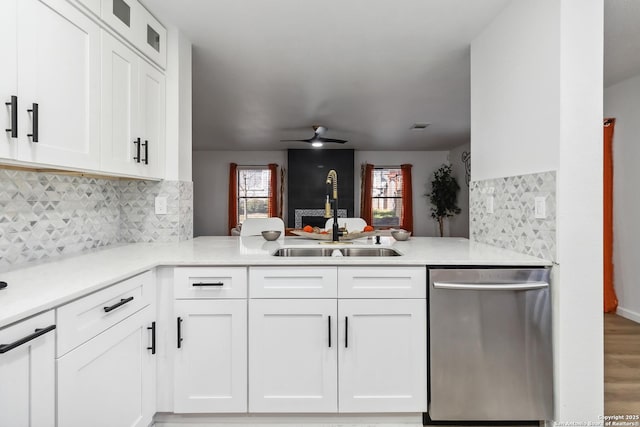 kitchen with a ceiling fan, dishwasher, a peninsula, white cabinetry, and a sink