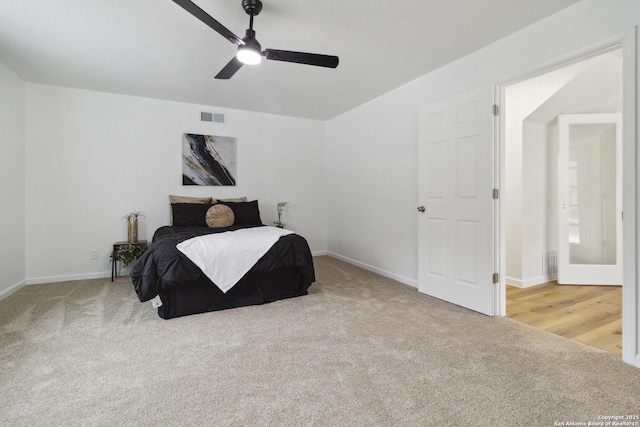 carpeted bedroom with a ceiling fan, visible vents, and baseboards