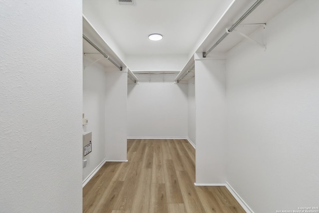 walk in closet with light wood-type flooring and visible vents