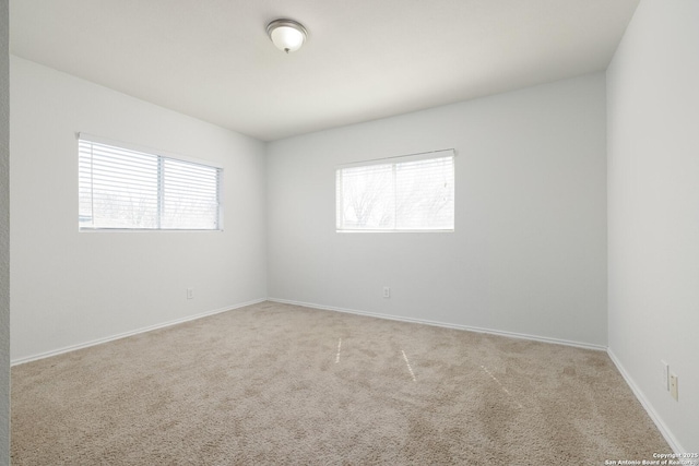 carpeted empty room with baseboards