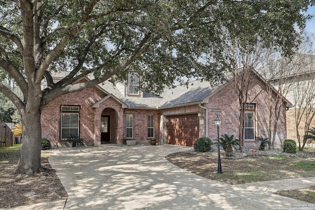 view of front facade featuring a garage, concrete driveway, brick siding, and a shingled roof