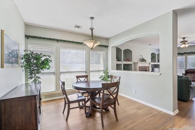 dining room with a wealth of natural light, baseboards, visible vents, and wood finished floors