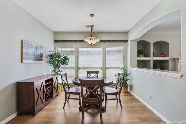 dining area with baseboards and wood finished floors