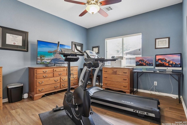 exercise room with ceiling fan, visible vents, baseboards, and wood finished floors