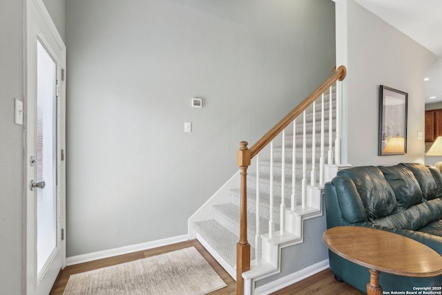 stairway featuring baseboards and wood finished floors