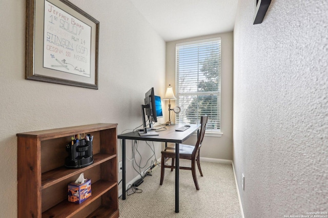 office with carpet, a textured wall, and baseboards