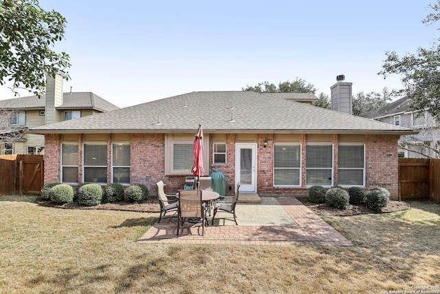 back of property with a patio area, fence, brick siding, and a lawn