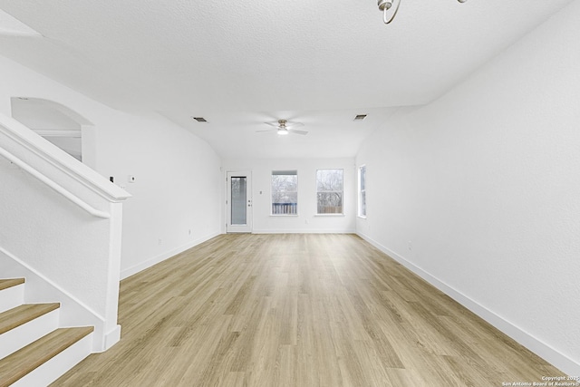 unfurnished living room with light wood finished floors, visible vents, stairway, ceiling fan, and baseboards