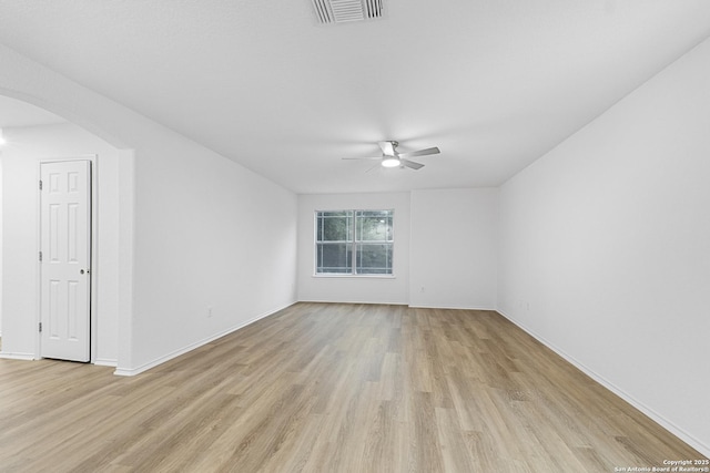 empty room with a ceiling fan, visible vents, light wood-style flooring, and baseboards