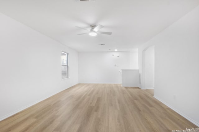 empty room with light wood-style floors, visible vents, ceiling fan, and baseboards