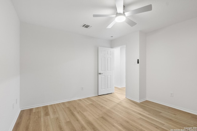 unfurnished room featuring light wood finished floors, ceiling fan, visible vents, and baseboards