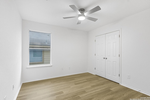 unfurnished bedroom featuring ceiling fan, a closet, wood finished floors, and baseboards