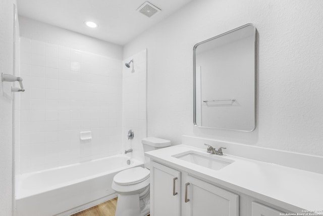 full bathroom with bathtub / shower combination, visible vents, toilet, vanity, and wood finished floors