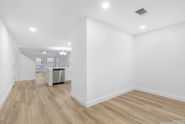 interior space with baseboards, light wood-type flooring, visible vents, and an inviting chandelier