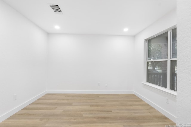 empty room featuring light wood-style flooring, recessed lighting, visible vents, and baseboards