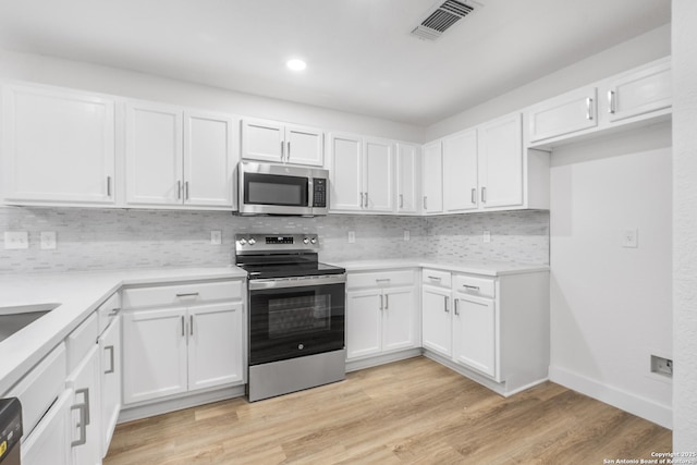 kitchen featuring stainless steel appliances, light wood-type flooring, and white cabinets