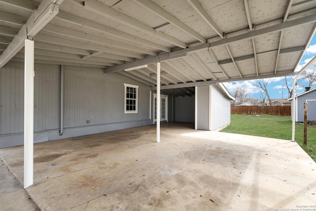 view of patio with a carport, french doors, and fence